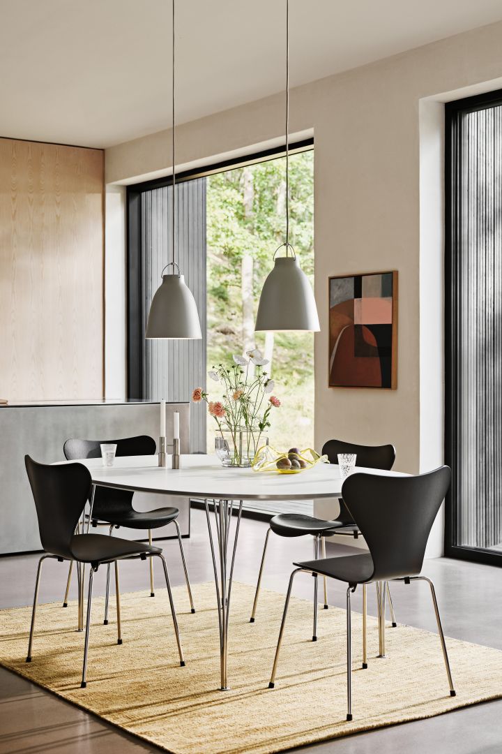 Sjuan stolar i svart placerade runt det klassiska Ellipse-bordet, från Fritz Hansen. Sjuan-stolarna är riktiga klassiker när det kommer till populära designstolar och finns i en mängd olika utföranden.