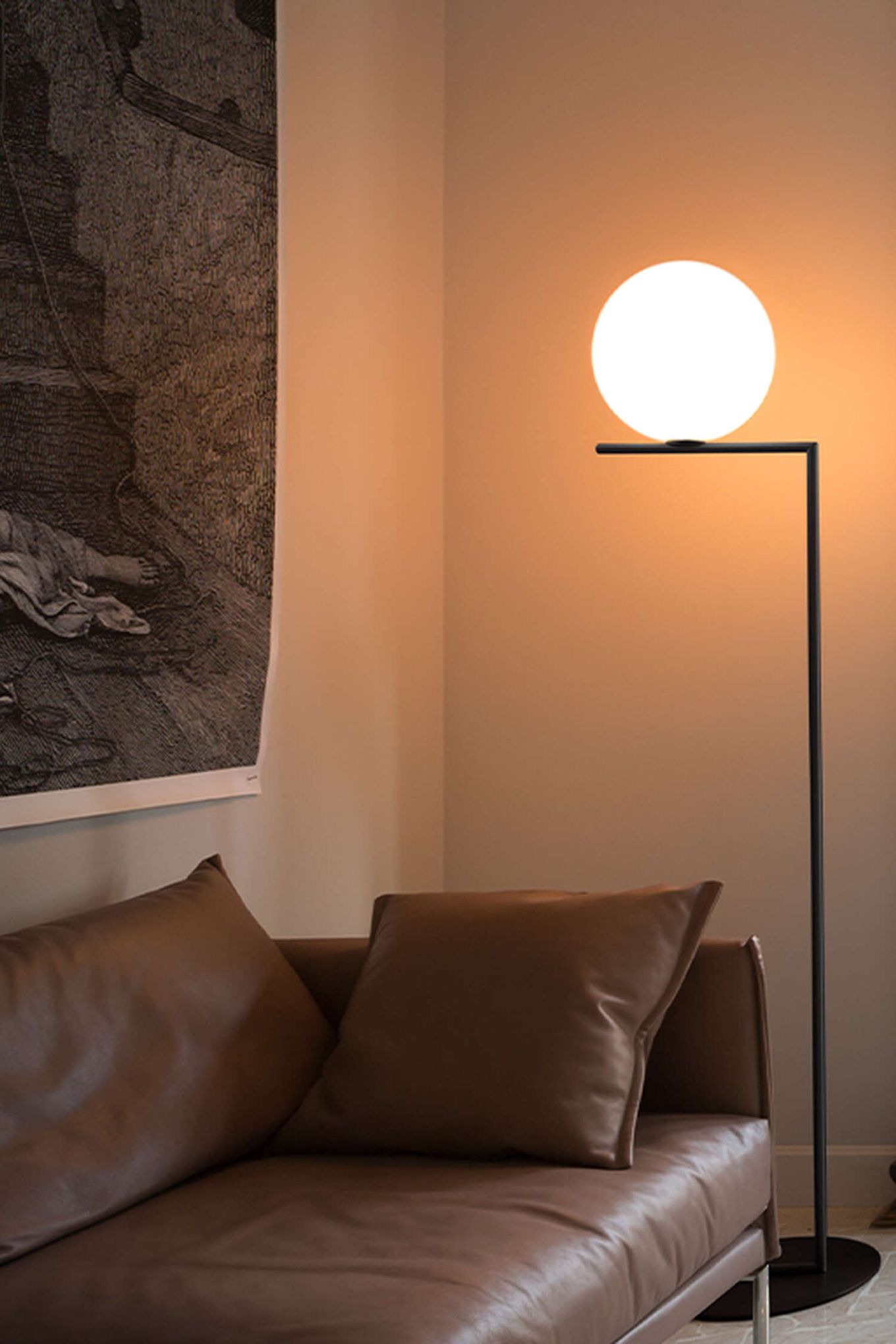 Från Flos kommer denna omtyckta golvlampa, IC Lights F1 har ett minimalistiskt formspråk med ett enkelt, rakt stativ och ett klot som ska symbolisera en sfär som nästan svävar. Här placerad intill en cognacsbrun lädersoffa.