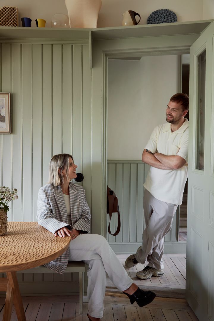 Familjen Stuart står i sitt hem med gröna paneler.