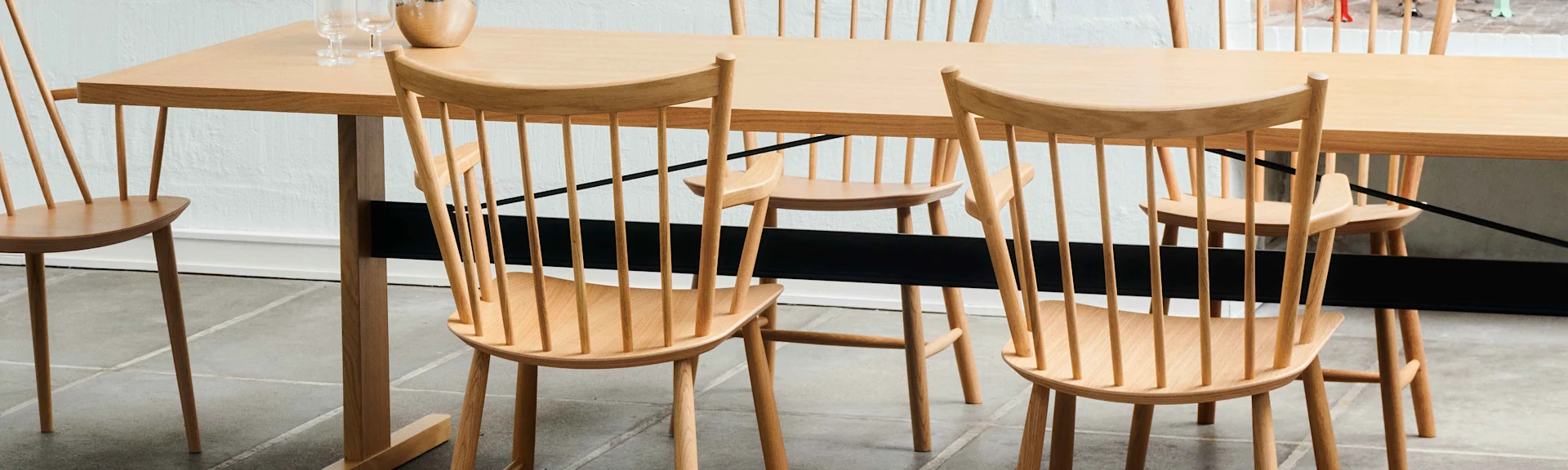 Ljust trämatbord med pinnstolar och glas på bordet.