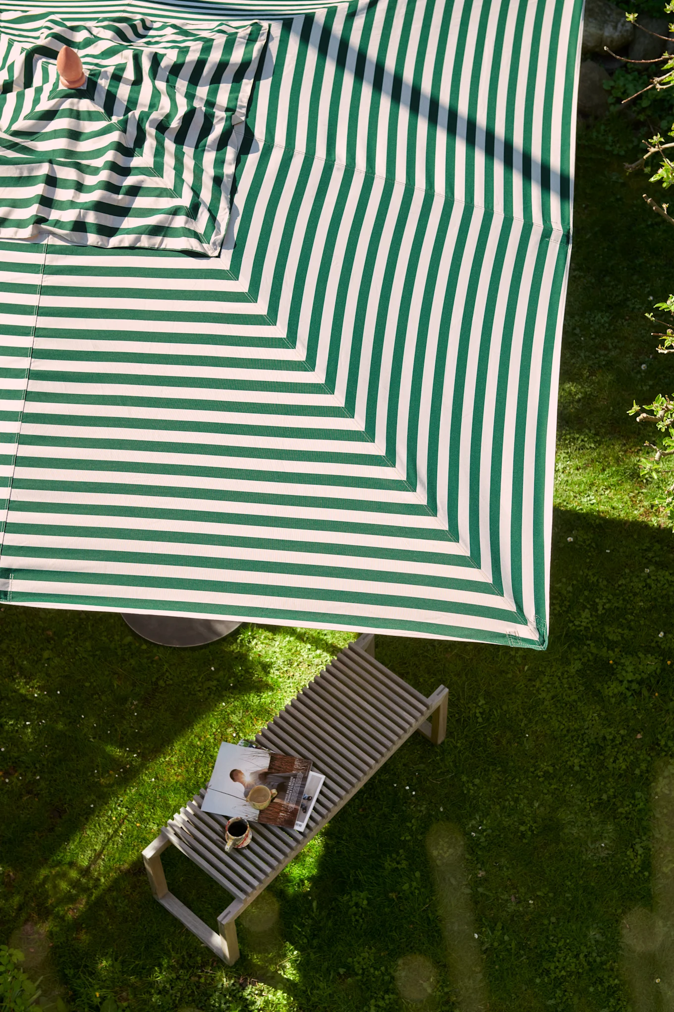 Rama in och ge uteplatsen skugga med Messina parasoll i grön- och vitrandigt från Skagerak.